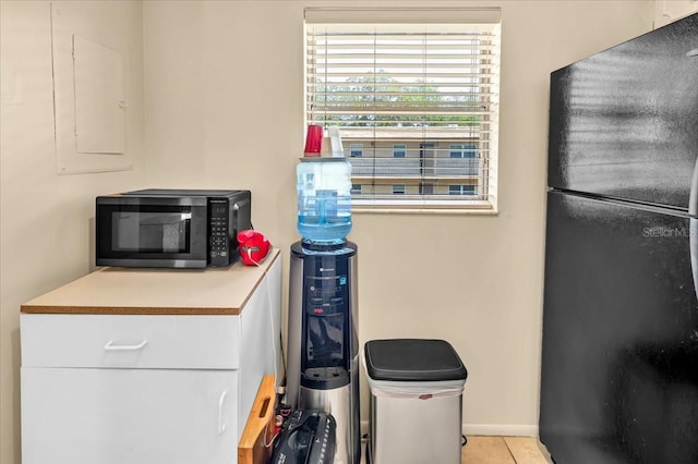 kitchen featuring black appliances and light tile flooring