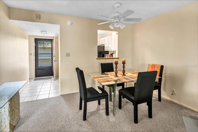 tiled dining area featuring a textured ceiling and ceiling fan