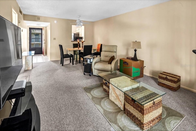 carpeted living room with ceiling fan and a textured ceiling