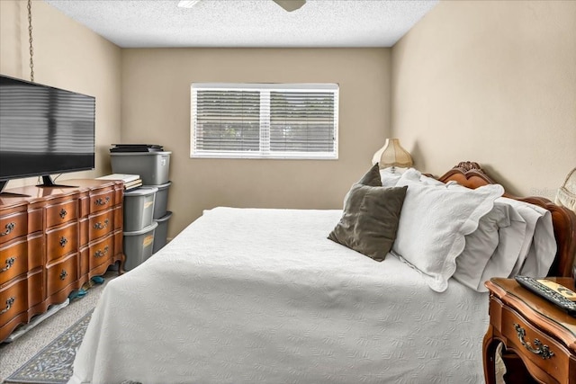 bedroom featuring ceiling fan, carpet, and a textured ceiling