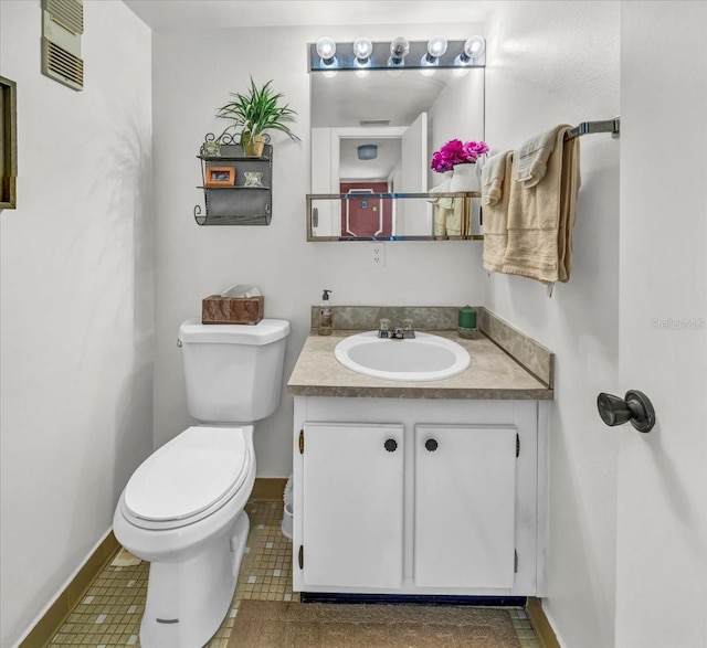 bathroom with tile flooring, vanity, and toilet