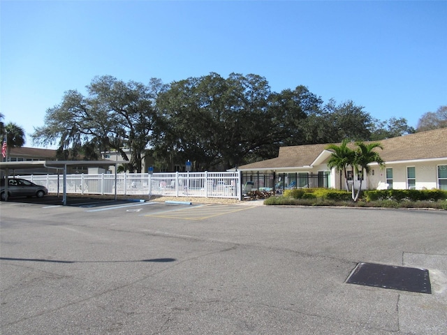 partially covered parking lot featuring fence