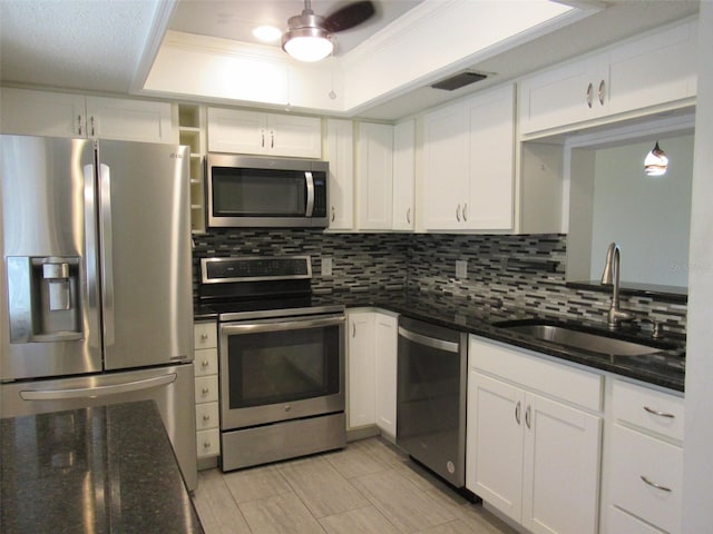 kitchen featuring stainless steel appliances, sink, ceiling fan, decorative backsplash, and white cabinets