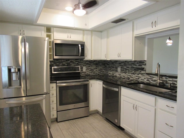 kitchen with a sink, visible vents, appliances with stainless steel finishes, backsplash, and a tray ceiling