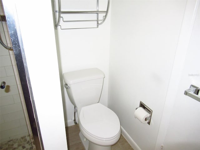 bathroom with tiled shower and toilet