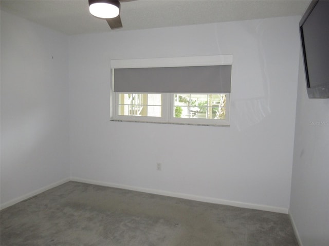 unfurnished room featuring carpet and baseboards