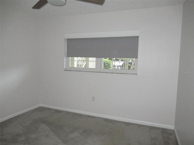 carpeted spare room with ceiling fan, a textured ceiling, and baseboards