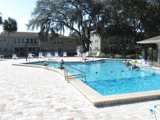 pool with fence and a patio