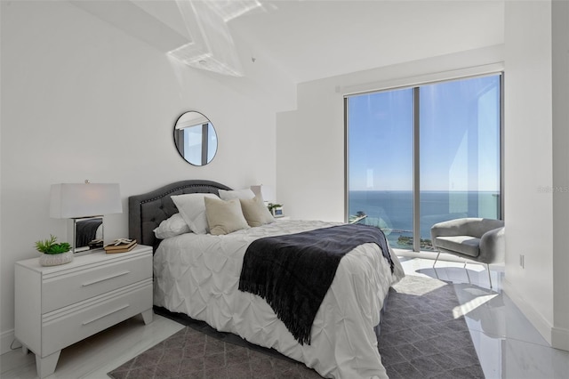 bedroom featuring access to exterior and a water view