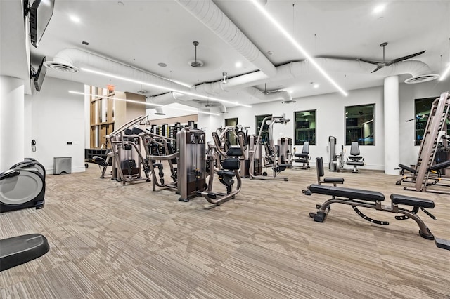 gym with ceiling fan and light carpet