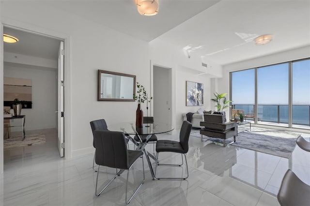 dining area with a water view and light tile flooring