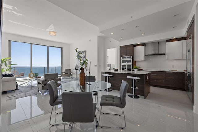 dining room with a water view and light tile floors