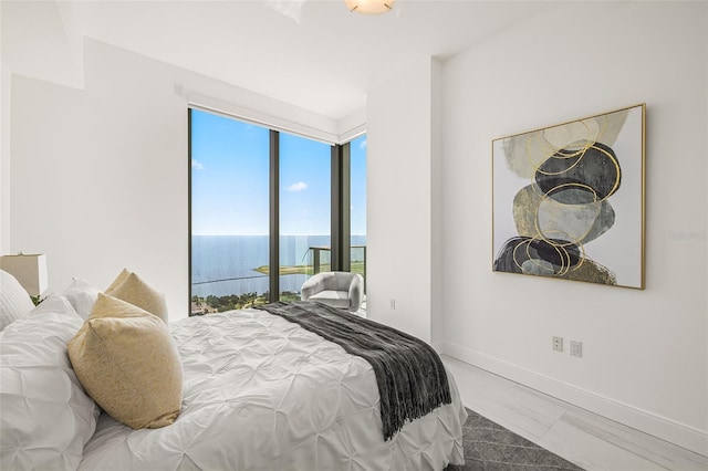 bedroom with a water view and wood-type flooring