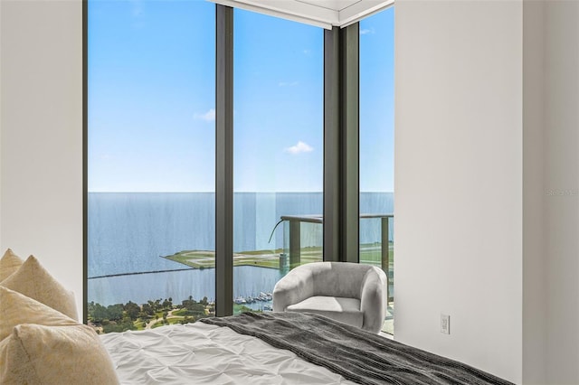 bedroom with a water view and a wall of windows