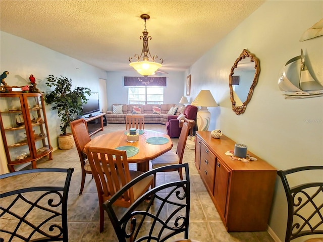 tiled dining space featuring a textured ceiling