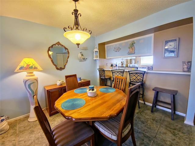 dining area with tile flooring and a textured ceiling