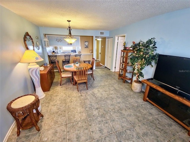 tiled dining space with a textured ceiling