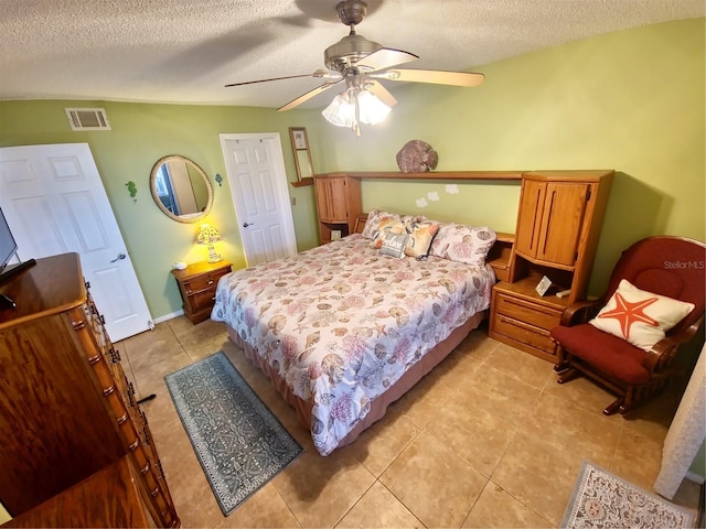 tiled bedroom featuring a textured ceiling and ceiling fan