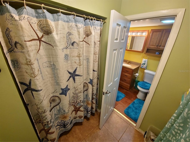 bathroom featuring toilet, tile floors, and vanity