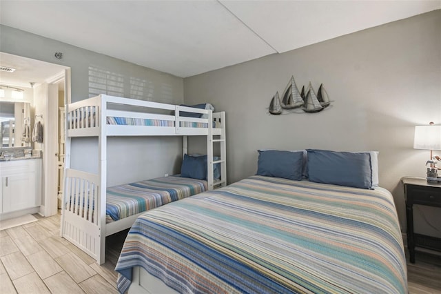 bedroom featuring light hardwood / wood-style flooring and ensuite bath