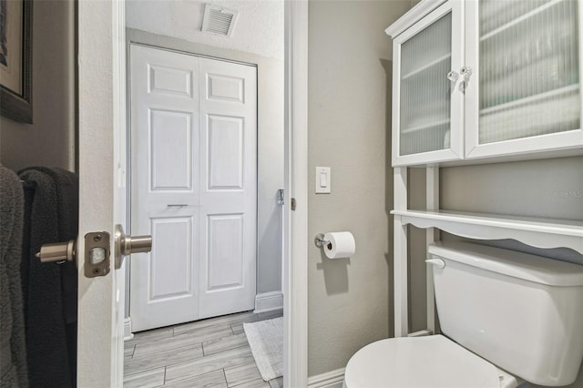 bathroom with toilet and hardwood / wood-style flooring