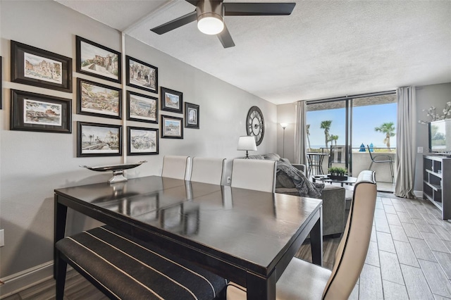 dining space featuring ceiling fan, light wood-type flooring, and a textured ceiling