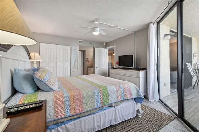 bedroom featuring access to exterior, ceiling fan, light hardwood / wood-style flooring, a textured ceiling, and a closet