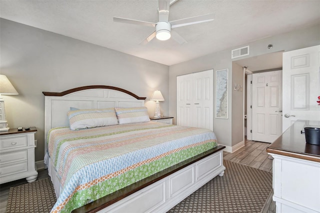 bedroom with ceiling fan, a closet, and dark hardwood / wood-style floors