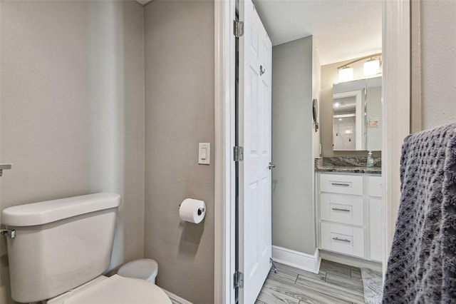 bathroom featuring toilet, vanity, and a textured ceiling