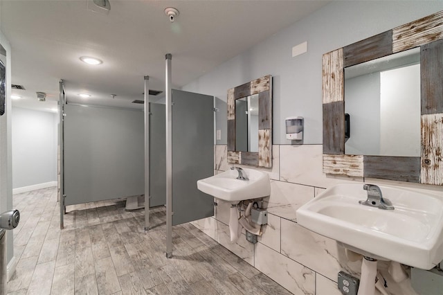 bathroom with sink, hardwood / wood-style flooring, and tile walls