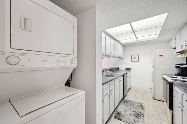 washroom with a textured ceiling, sink, stacked washer and dryer, and light tile floors