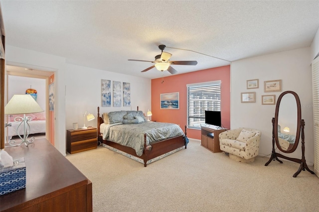 carpeted bedroom with a textured ceiling and ceiling fan