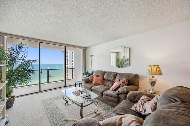 living room with carpet, a wall of windows, a textured ceiling, and a water view