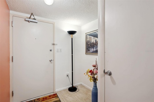 foyer entrance with tile flooring and a textured ceiling