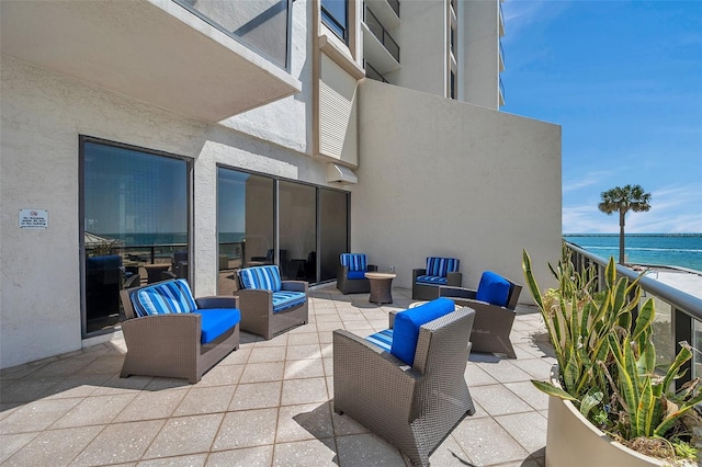 view of patio / terrace with an outdoor living space, a water view, and a balcony