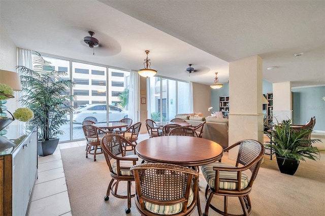 dining room with ceiling fan, a wall of windows, and light tile flooring