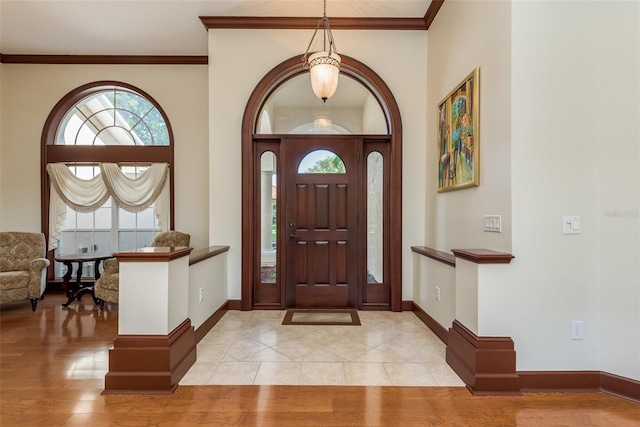 tiled foyer featuring ornamental molding