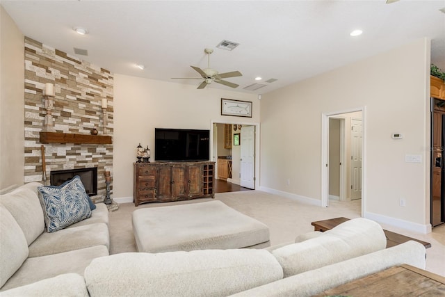 living room with ceiling fan and a stone fireplace