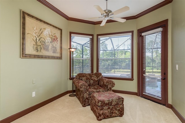 living area featuring plenty of natural light, carpet, crown molding, and ceiling fan