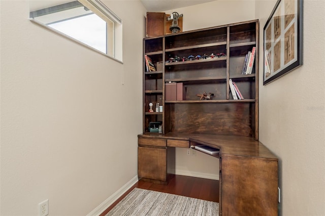 unfurnished office featuring built in desk and wood-type flooring