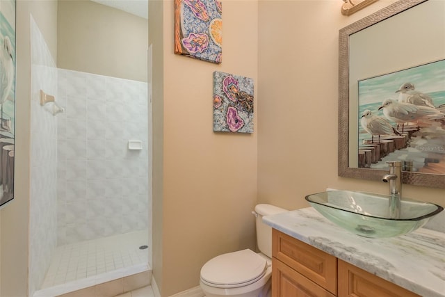 bathroom featuring tiled shower, vanity, and toilet