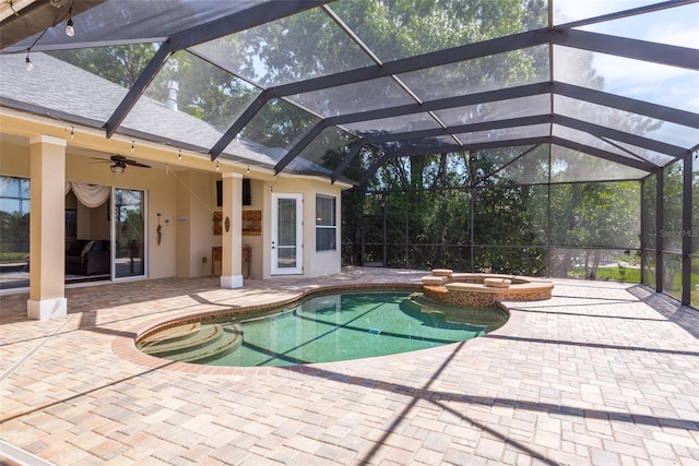 view of pool with a patio, glass enclosure, an in ground hot tub, and ceiling fan