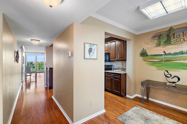 corridor with hardwood / wood-style flooring and crown molding