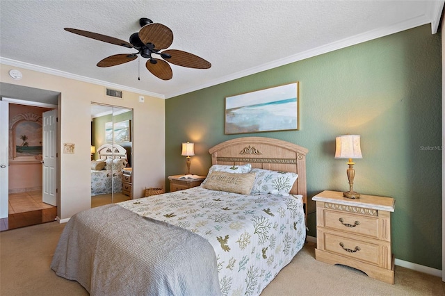 carpeted bedroom with ceiling fan, a closet, a textured ceiling, and ornamental molding