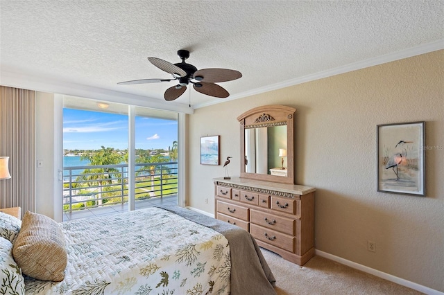 bedroom featuring access to exterior, light colored carpet, ceiling fan, crown molding, and a water view