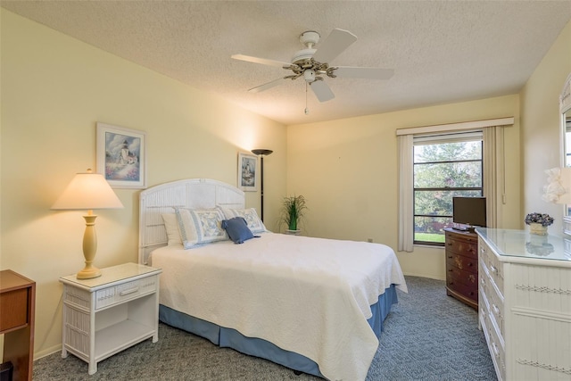 bedroom featuring ceiling fan, dark carpet, and a textured ceiling