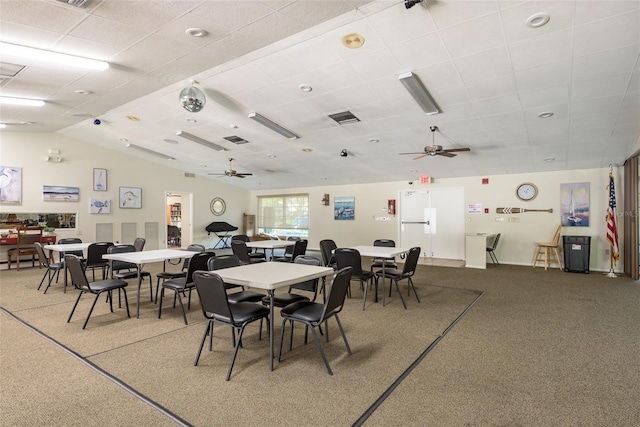 carpeted dining area with a drop ceiling and ceiling fan