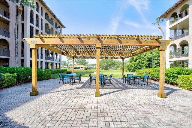 view of property's community featuring a patio area, a yard, and a pergola