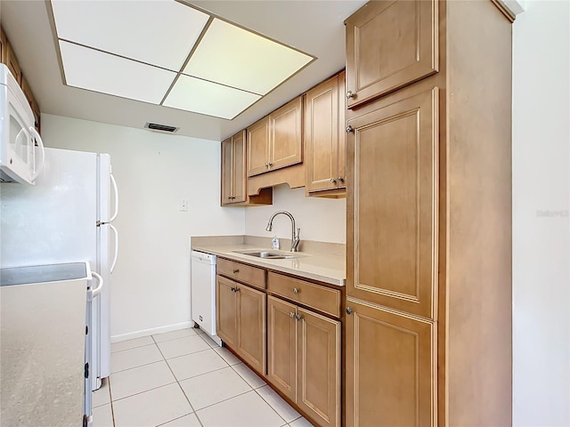 kitchen with sink, light brown cabinets, light tile patterned flooring, and white appliances