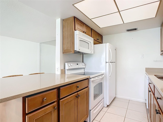 kitchen with light tile patterned floors and white appliances